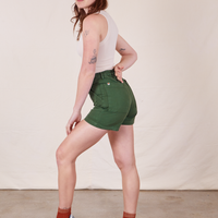 Side view of Classic Work Shorts in Dark Emerald Green and vintage off-white Tank Top worn by Alex