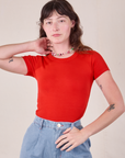 Alex is wearing Baby Tee in Mustang Red tucked into light wash Trouser Jeans