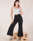 Alex is 5'8" and wearing XXS Bell Bottoms in Basic Black paired with a Cropped Cami in vintage tee off-white