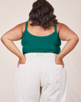 Back view of Cropped Cami in Hunter Green and vintage tee off-white Western Pants worn by Alicia. She has both hands in the back pant pockets.