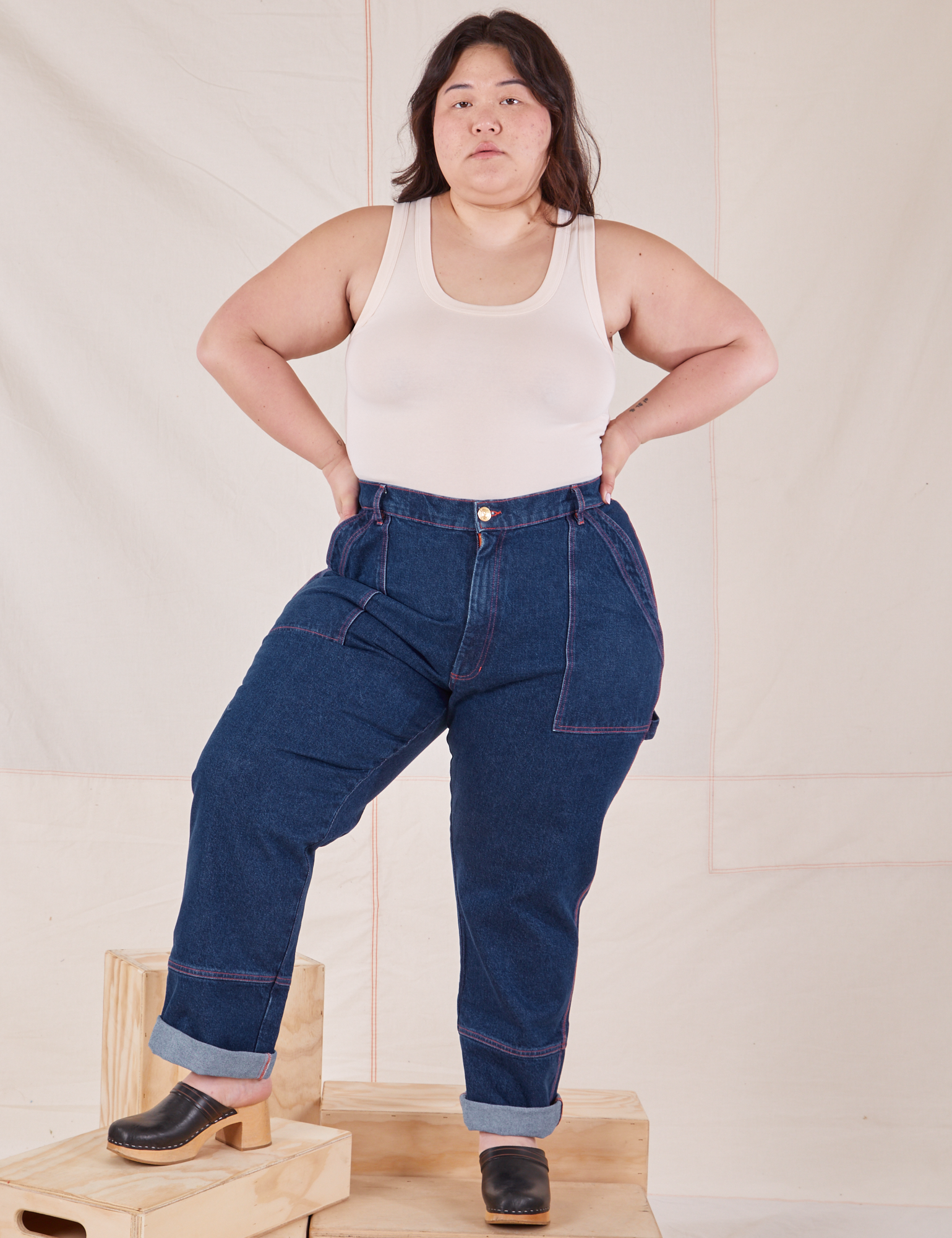 Ashley is 5&#39;7&quot; and wearing 1XL Carpenter Jeans in Dark Wash paired with Tank Top in vintage tee off-white