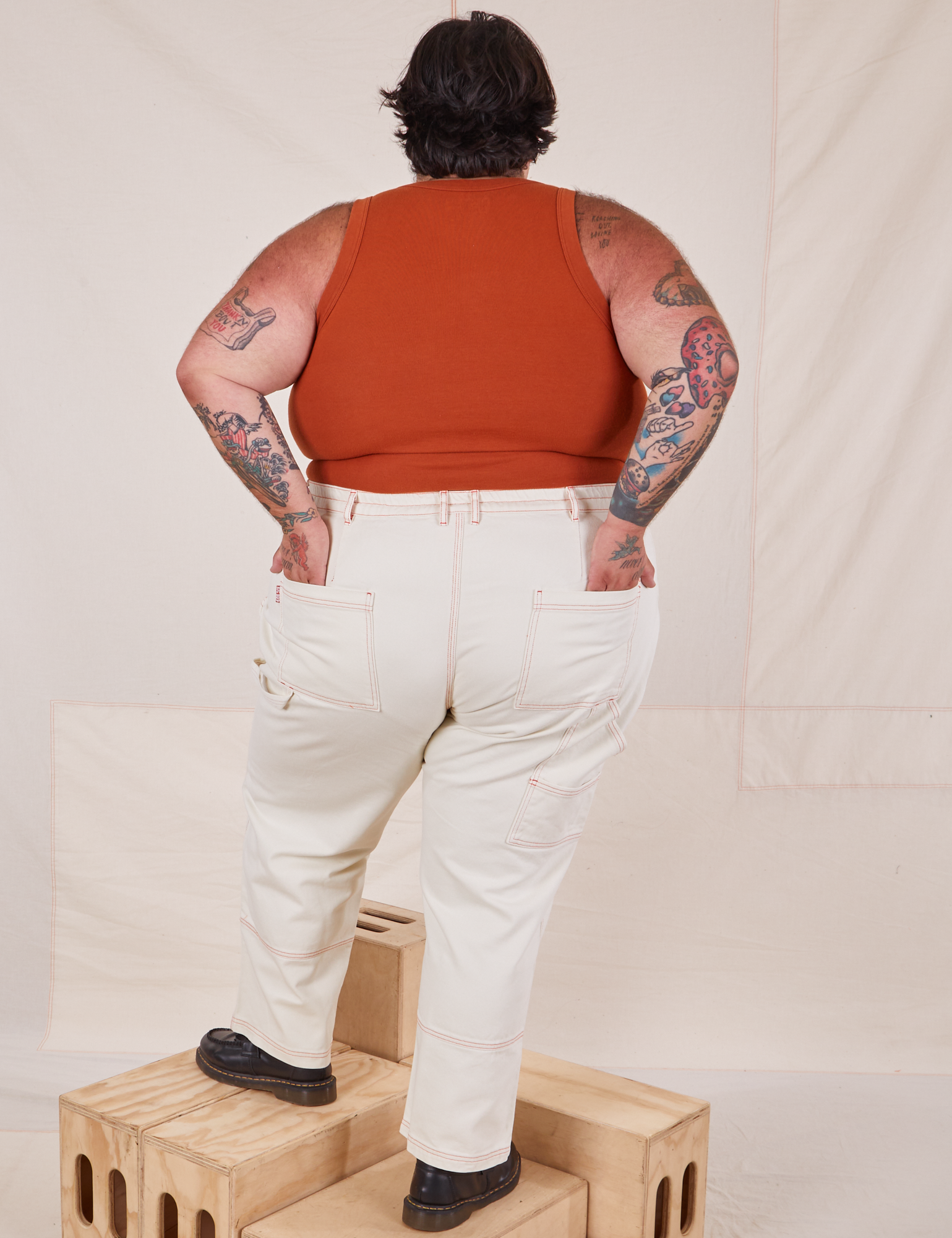 Back view of Carpenter Jeans in Vintage Off-White and burnt terracotta Cropped Tank Top on Sam