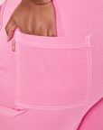 Carpenter Jeans in Bubblegum Pink back pocket close up. Morgan has her hand partially tucked into the pocket.