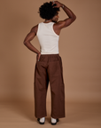 Back view of Drop Pocket Cargo Pants in Fudgesicle Brown and Tank Top in vintage tee white on Jerrod