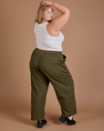 Angled back view of Drop Pocket Cargo Pants in Surplus Green and Cropped Tank in Vintage Tee White