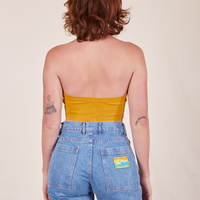 Back view of Halter Top in Mustard Yellow and light wash Frontier Jeans worn by Alex