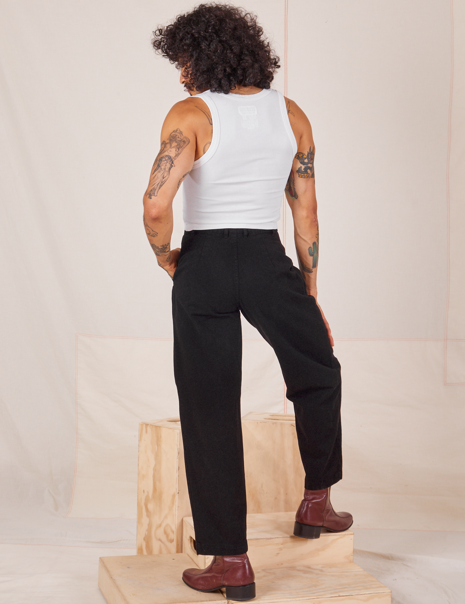 Back view of Heavyweight Trousers in Basic Black and Cropped Tank Top in vintage tee off-white worn by Jesse