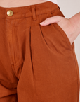 Front pocket close up of Heavyweight Trousers in Burnt Terracotta. Alex has her hand in the pocket.