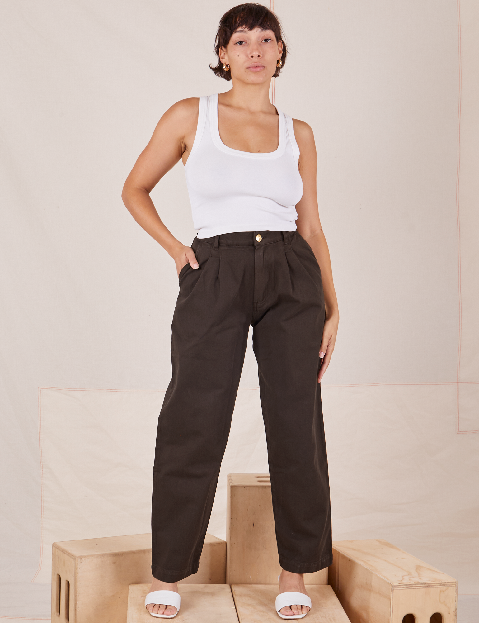 Tiara is 5&#39;4&quot; and wearing S Heavyweight Trousers in Espresso Brown paired with Cropped Tank Top in vintage tee off-white