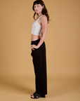 Side view of Baggy Mid-Rise Trousers in Basic Black and vintage tee white Cropped Tank on Alex