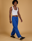 Angled front view of Baggy Mid-Rise Trousers in Royal Blue and vintage tee white Cropped Tank on Jerrod