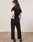 Petite Short Sleeve Jumpsuit in Basic Black back view on Hana with her hand in the back pocket.