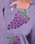Close up of Madeline's hand in the back pocket of Paintstamped Work Pants in Grape