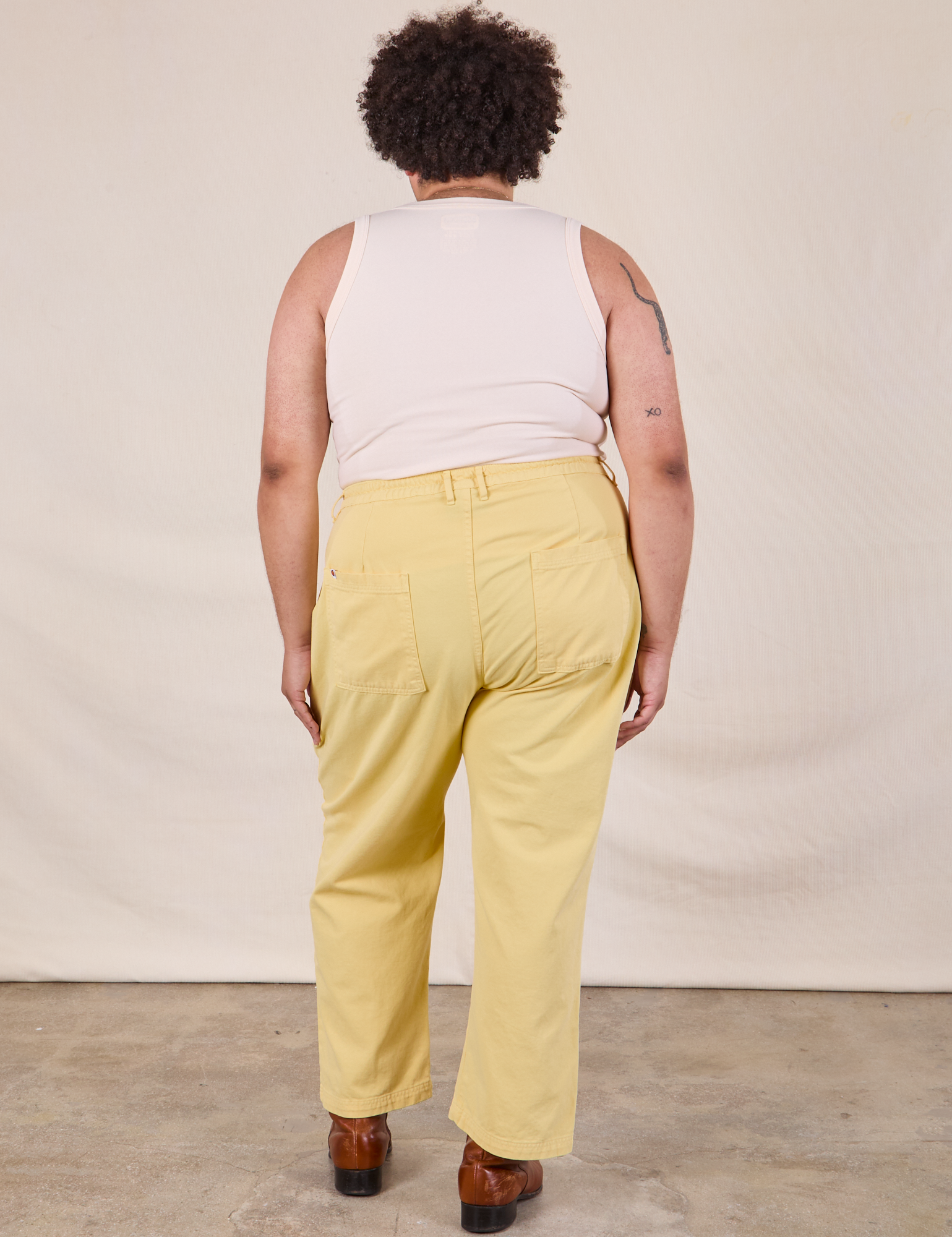 Back view of Work Pants in Butter Yellow and Tank Top in vintage tee off-white on Miguel