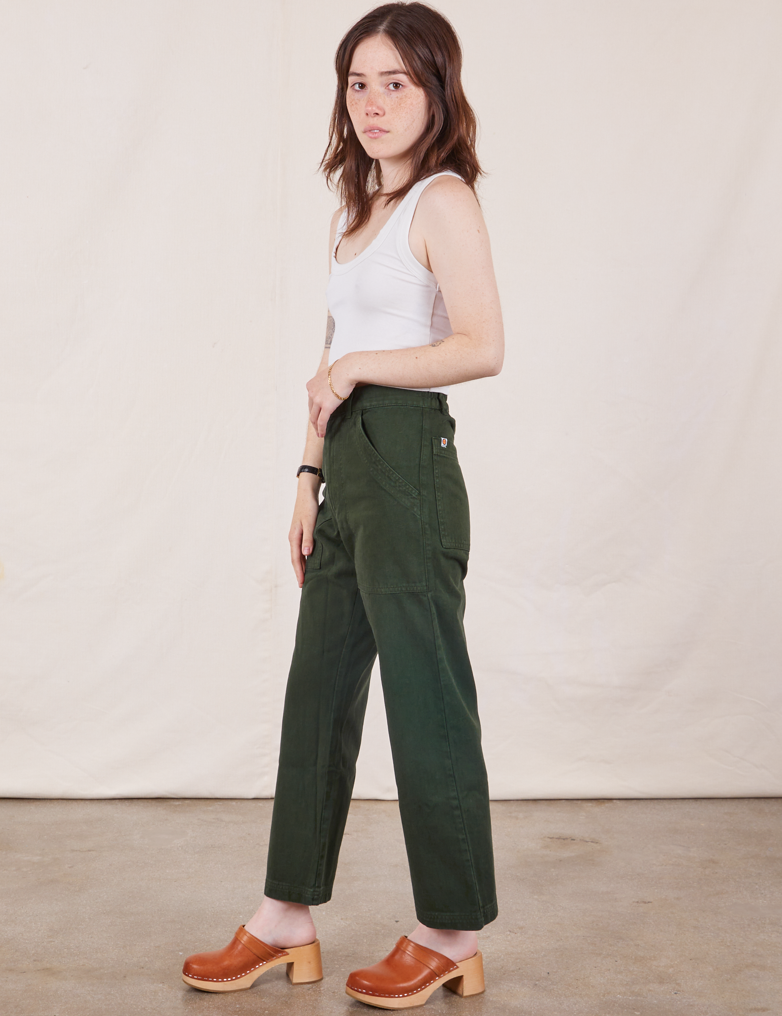 Side view of Petite Work Pants in Swamp Green and Cropped Tank Top in vintage tee off-white on Hana