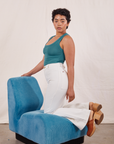 Mika is kneeling on a bright blue upholstered chair wearing Tank Top in Marine Blue and vintage tee off-white Western Pants