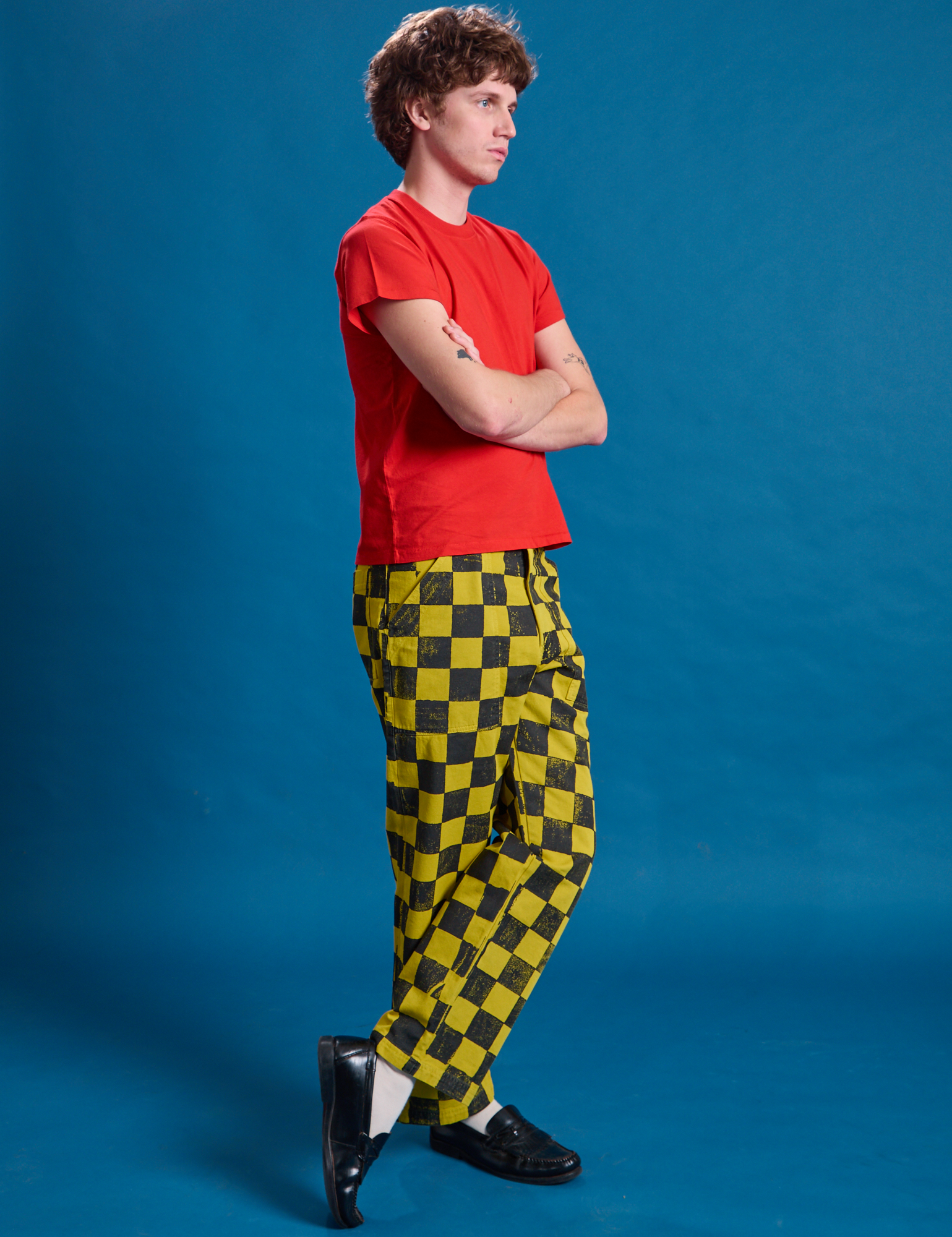 Side view of Checkerboard Work Pants in Yellow/Black and mustang red Organic Vintage Tee on Quinn