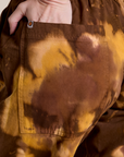 Close up of Alex's hand in the back pocket of Magic Waters Drop Pocket Pants in Honey Brown