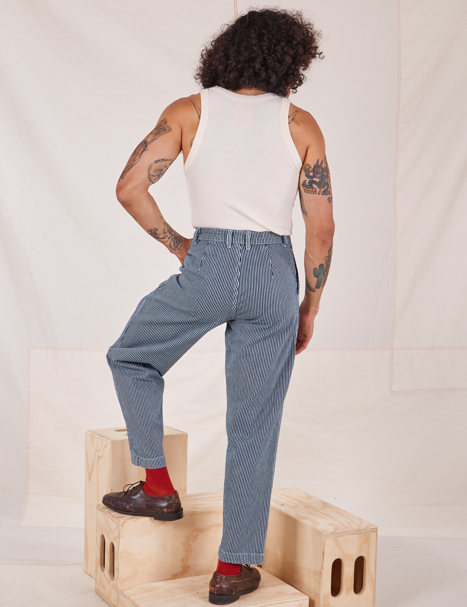 Back view of Denim Trouser Jeans in Railroad Stripe and Tank Top in vintage tee off-white worn by Jesse