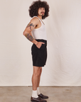 Side view of Trouser Shorts in Basic Black and vintage off-white Tank Top worn by Jesse