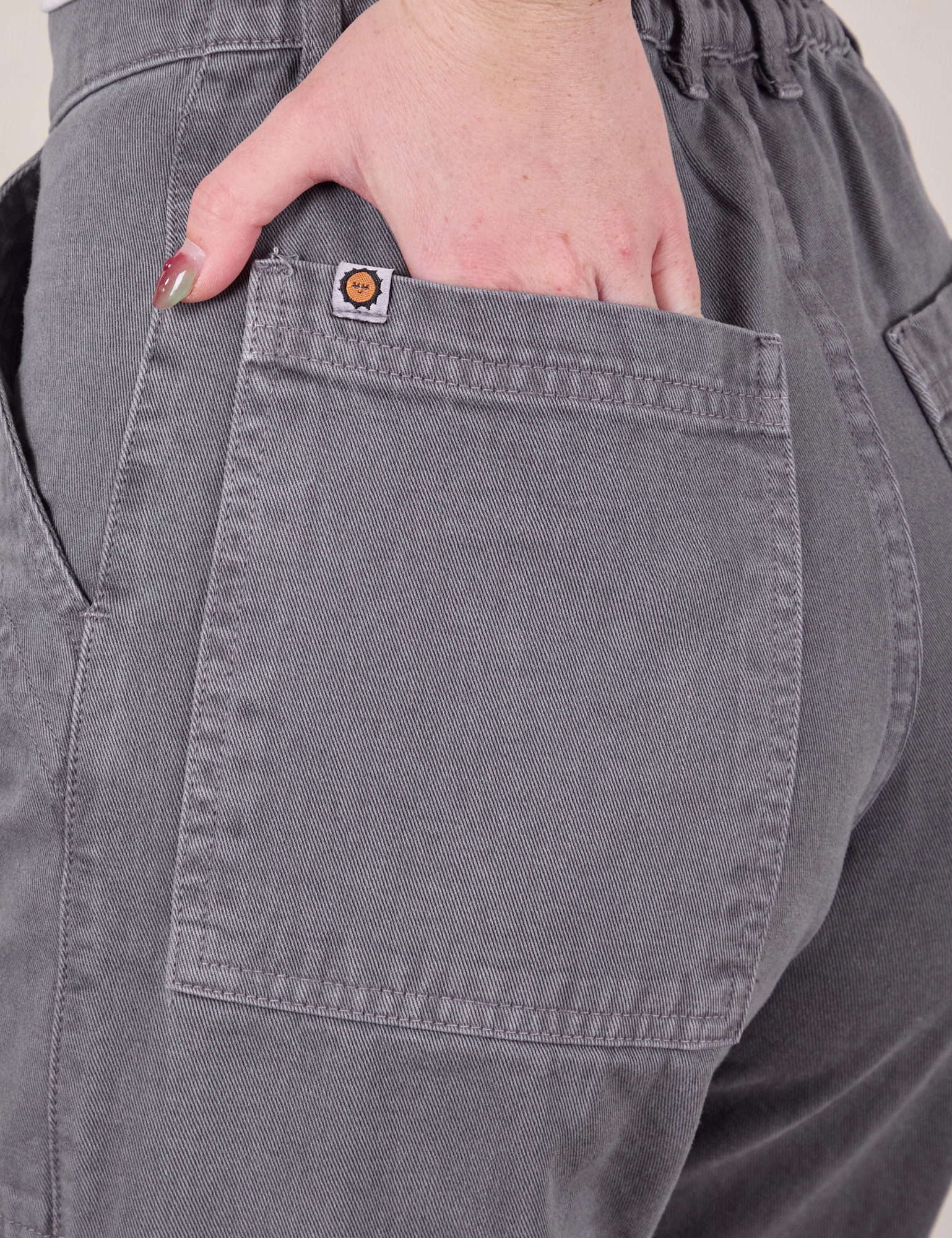 Close up of Hana's hand in the back pocket of Work Pants in Washed Grey