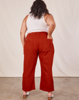 Back view of Western Pants in Paprika and Tank Top in vintage tee off-white worn by Alicia. She also has one hand in the pocket.