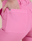 Close up of Alex's hand in the back pocket of Work Pants in Bubblegum Pink