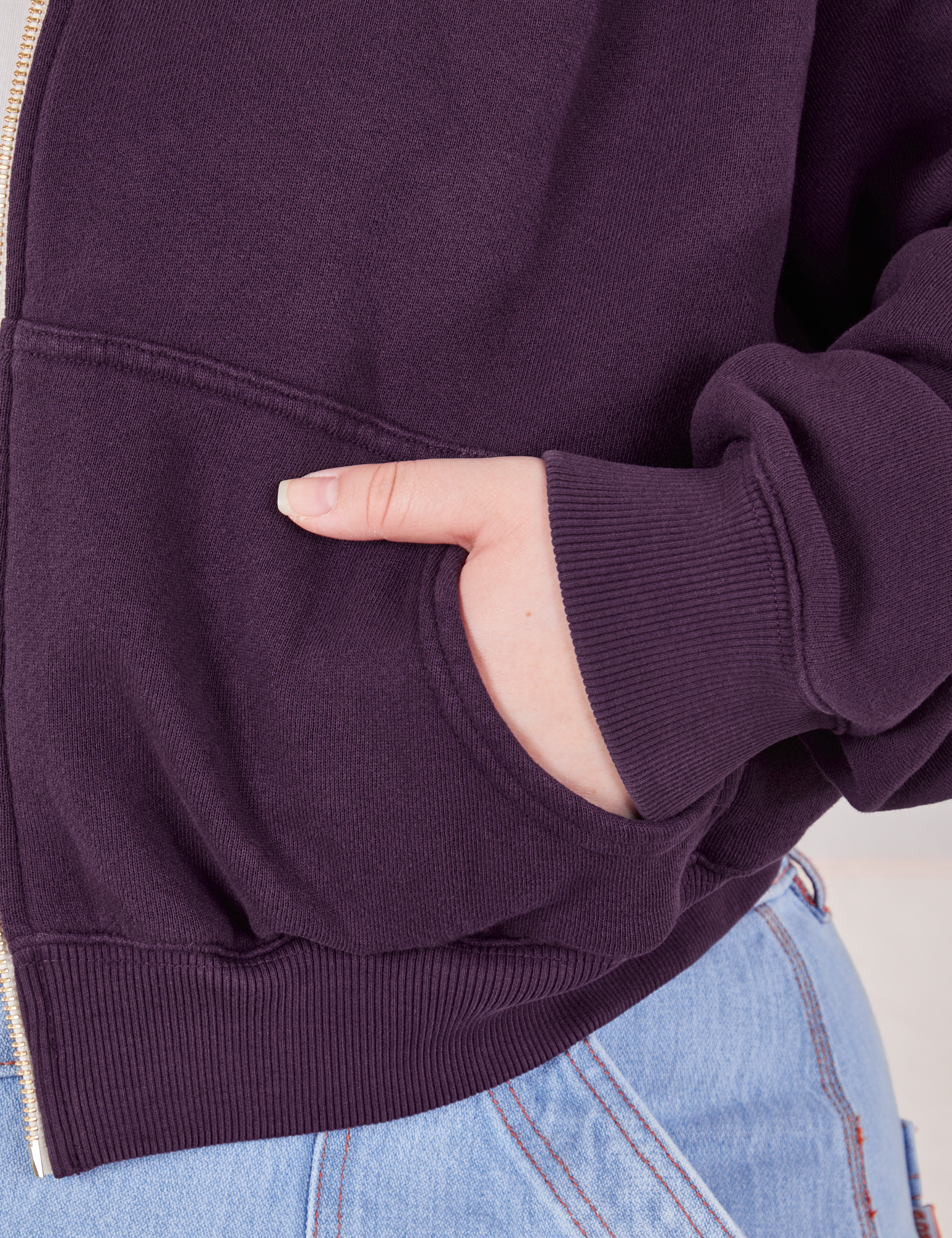 Cropped Zip Hoodie in Nebula Purple front pocket close up. Ashley has her hand in the pocket.
