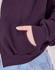Cropped Zip Hoodie in Nebula Purple front pocket close up. Ashley has her hand in the pocket.