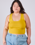 Ashley is 5'7" and wearing L Cropped Tank Top in Golden Yellow