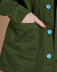 Close up of Alex's hand in the front pocket of Ripstop Field Coat in Evergreen