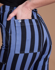 Close up of Alex's hand in the back pocket of Black Stripe Work Pants in Cornflower Blue