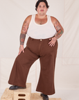 Sam is 5'10" and wearing 3XL Bell Bottoms in Fudgesicle Brown paired with a Tank Top in vintage tee off-white