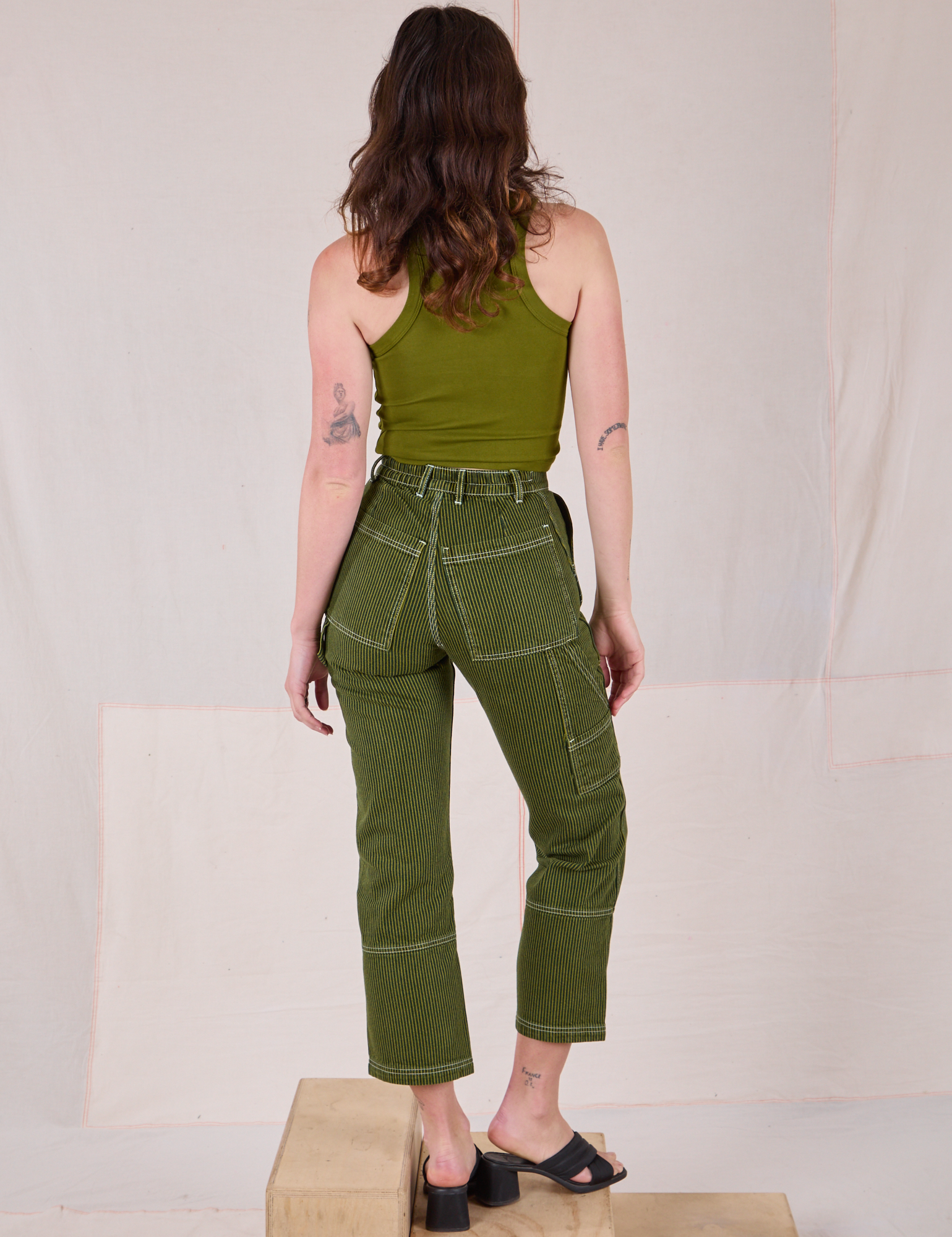 Back view of Railroad Carpenter Jeans in Summer Olive and muscle tee on Alex