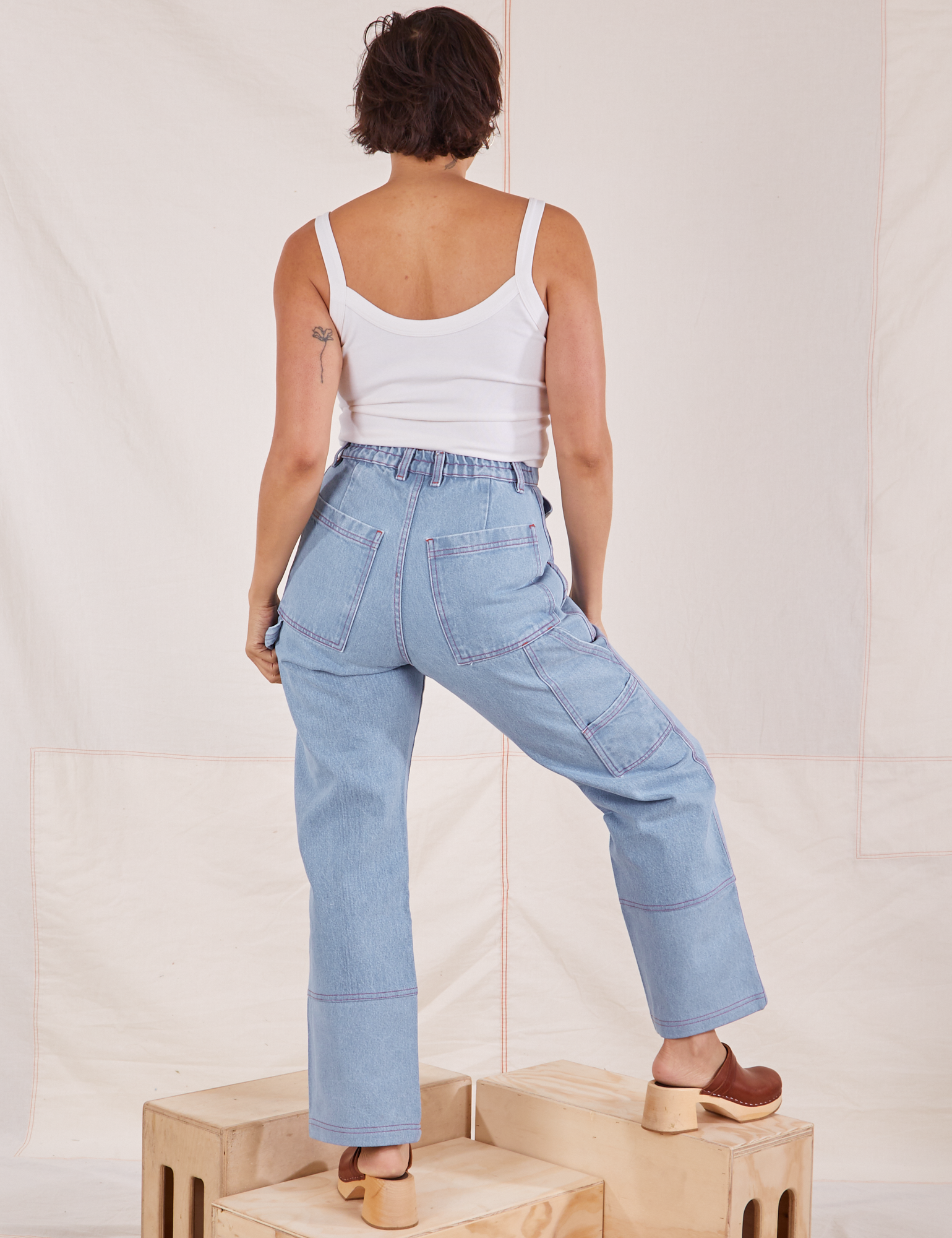 Back view of Carpenter Jeans in Light Wash and Cropped Cami in vintage tee off-white worn by Tiara