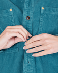Front close up of Corduroy Overshirt in Marine Blue. Alex is buttoning up the shirt.