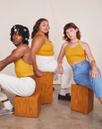 Alex, Alicia and Jerrod are sitting on wooden blocks all wearing Halter Top in Mustard Yellow