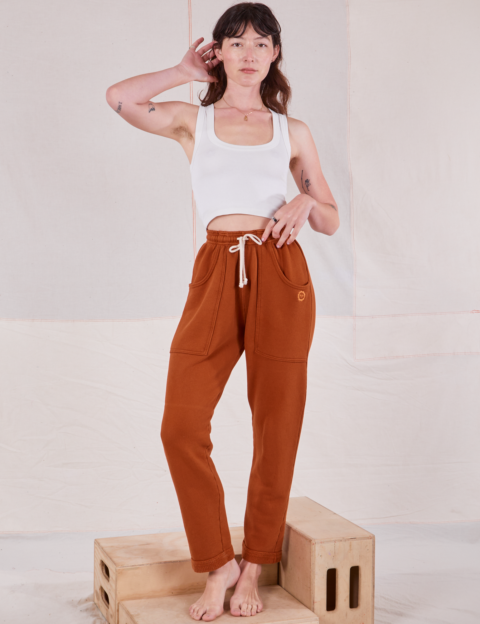 Alex is 5&#39;8&quot; and wearing P Rolled Cuff Sweat Pants in Burnt Terracotta paired with vintage off-white Cropped Tank