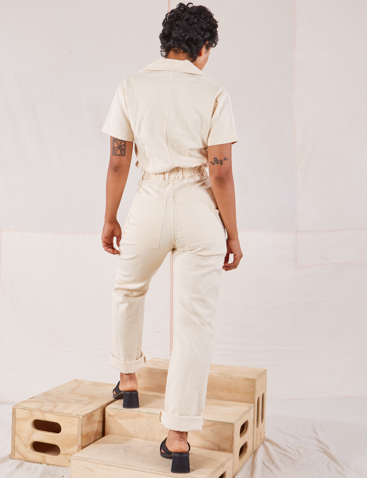 Heritage Short Sleeve Jumpsuit in Natural back view on Mika