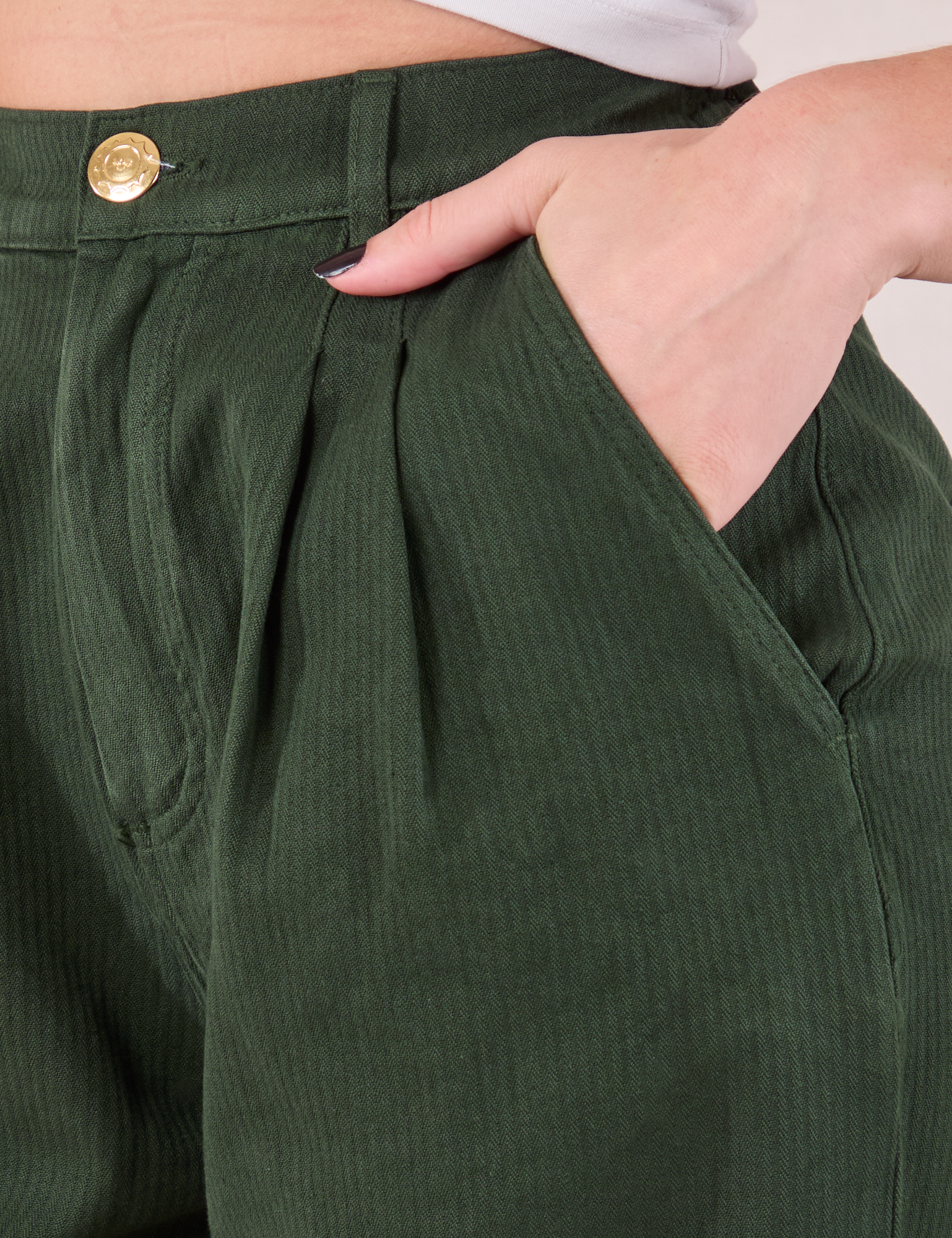 Heritage Trousers in Swamp Green front pocket close up. Alex has her hand in the pocket.