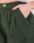 Heritage Trousers in Swamp Green front pocket close up. Alex has her hand in the pocket.