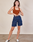 Alex is wearing Carpenter Shorts in Dark Wash and burnt terracotta Cropped Tank