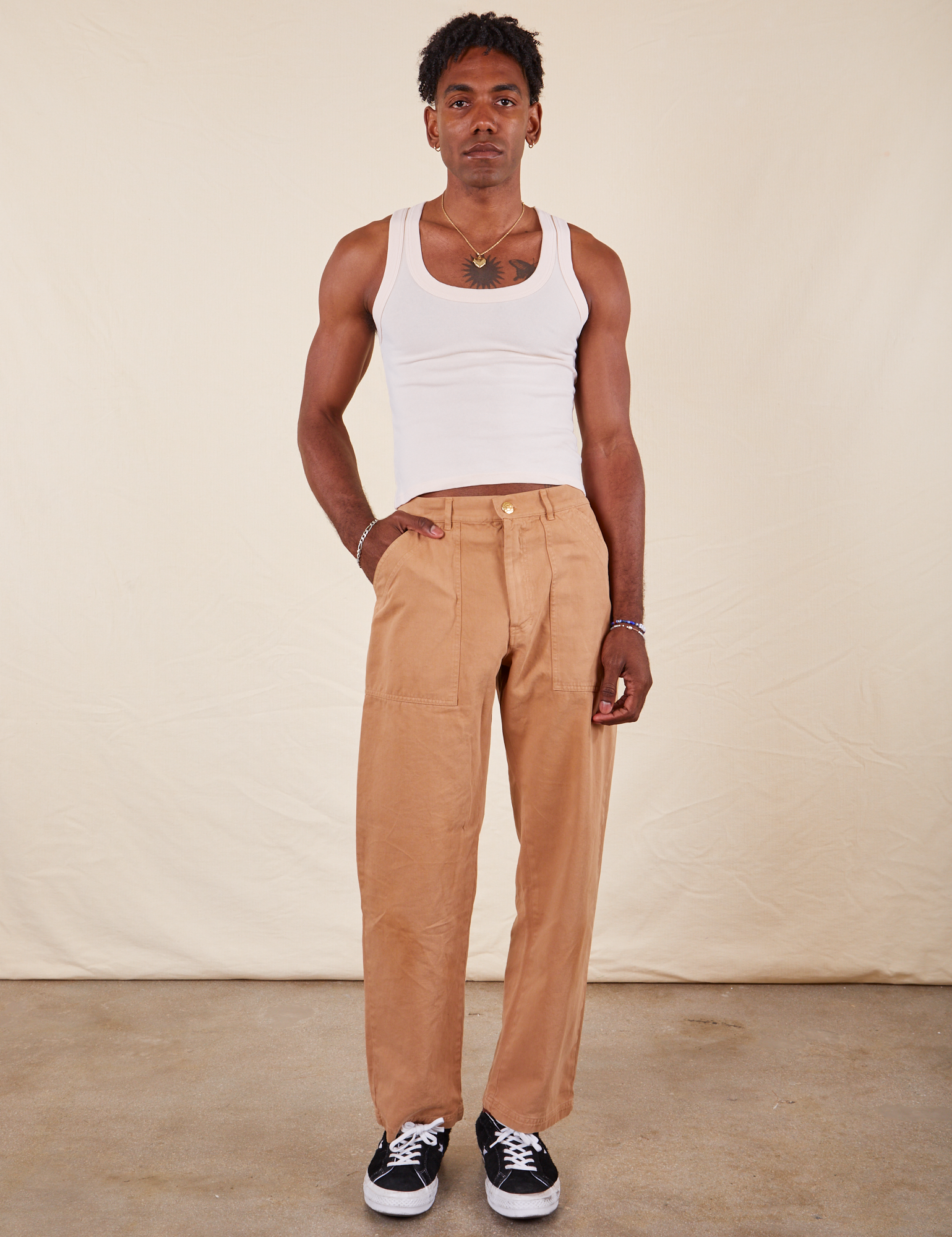 Jerrod is 6&#39;3&quot; S Long Work Pants in tan and wearing paired with Tank Top in vintage tee off-white