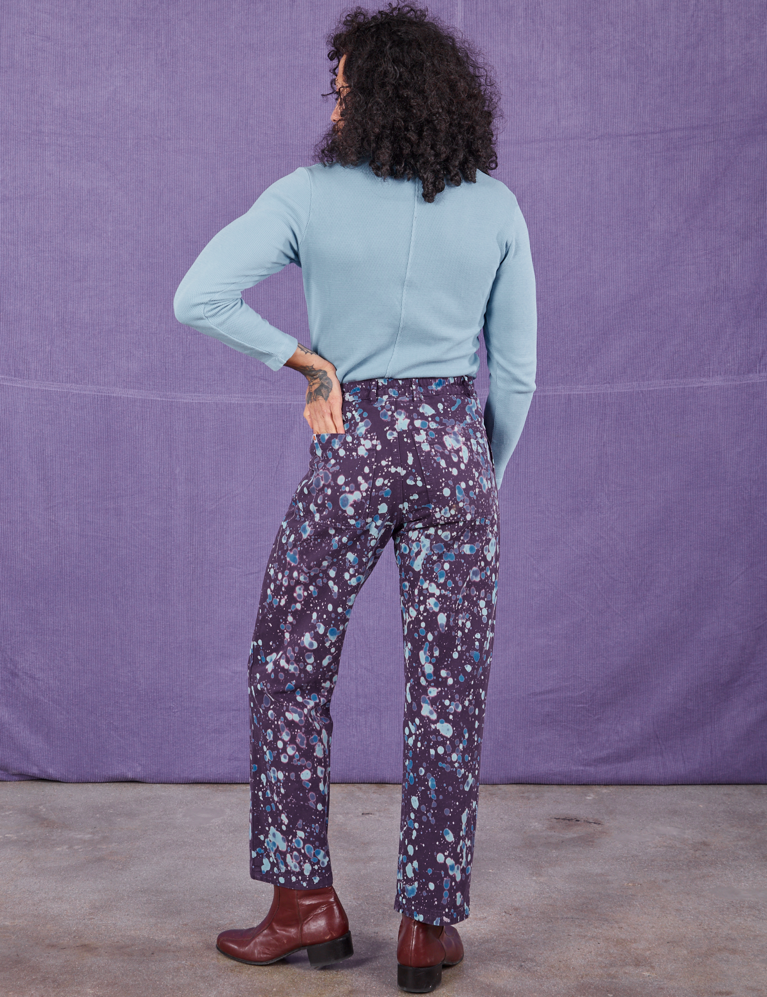 Back view of Marble Splatter Work Pants in Nebula Purple and baby blue Long Sleeve Fisherman Polo on Jesse