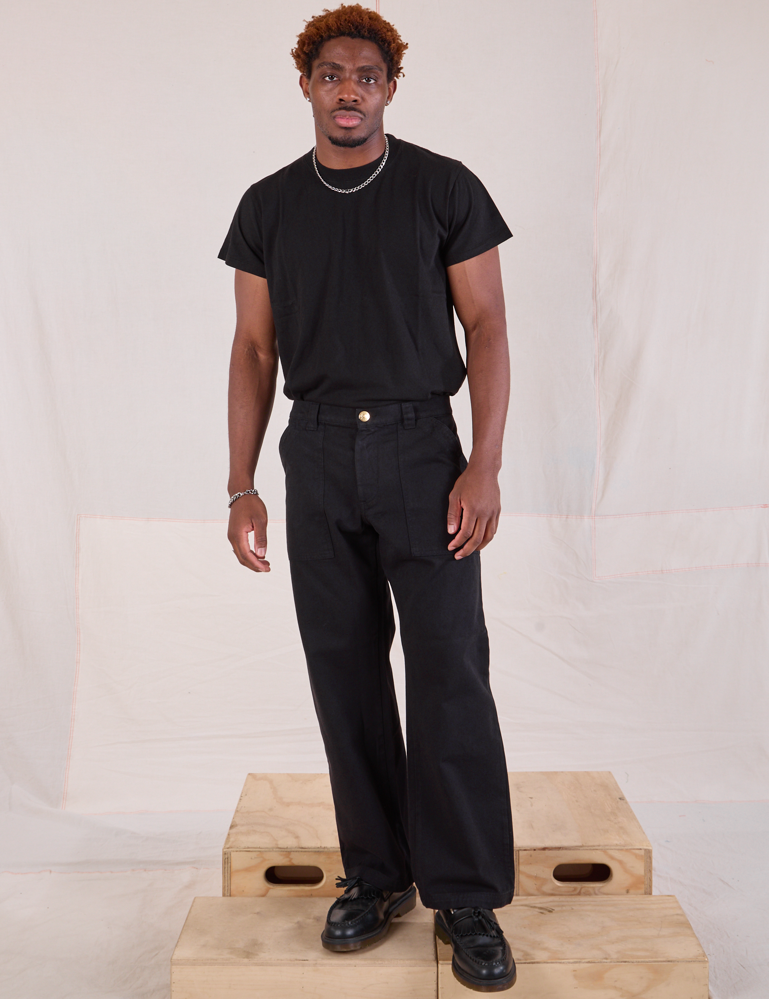 Issac is 5'10" and wearing M Mid-Rise Work Pants in Basic Black paired with black Organic Vintage Tee