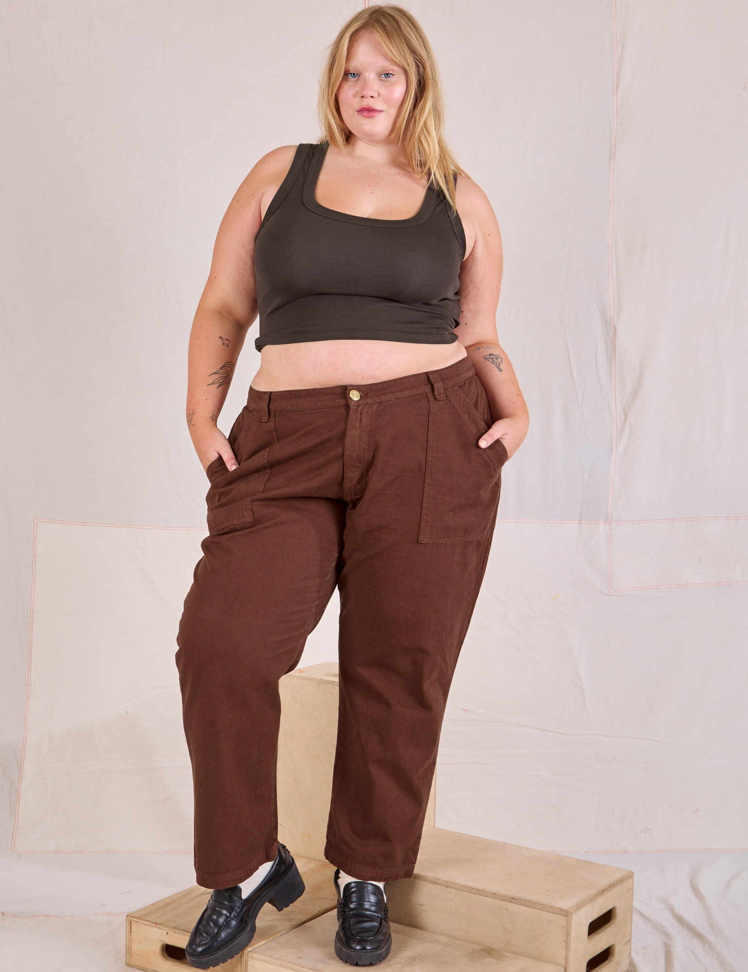 Juliet is 5'7" and wearing 2XL Mid-Rise Work Pants in Fudgesicle Brown paired with espresso brown Cropped Tank