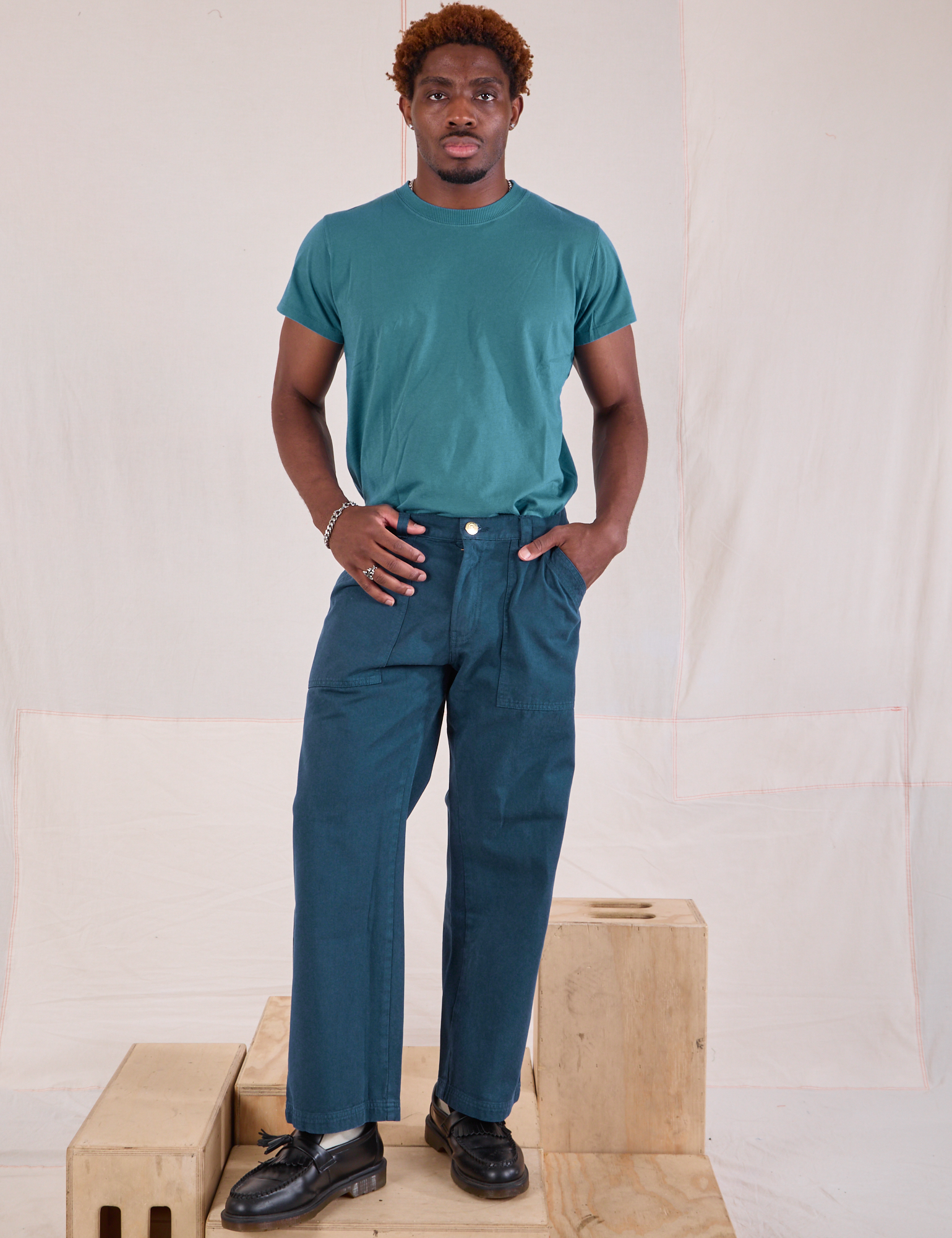 Issac is 5'10" and wearing M Mid-Rise Work Pants in Lagoon paired with marine blue Organic Vintage Tee