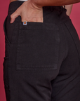 Close up of Alex's hand in the back pocket of Paintstamped Work Pants in Poppy