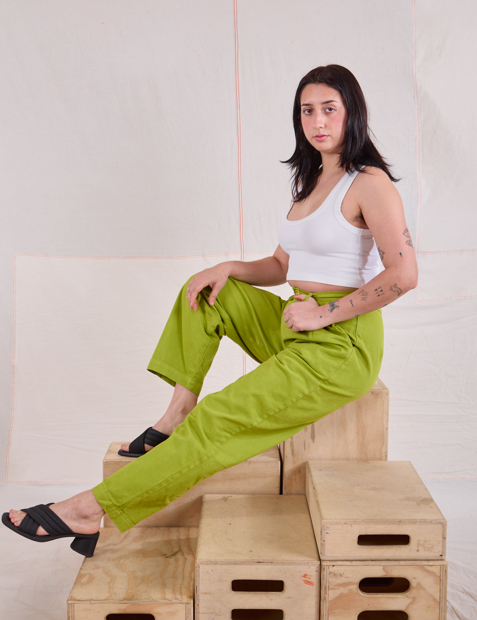 Heavyweight Trousers in Gross Green on Betty sitting on a wooden crate