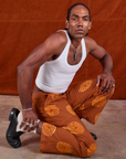 Jerrod is wearing Paintstamped Work Pants in Orange and Cropped Tank in Vintage Tee Off-White